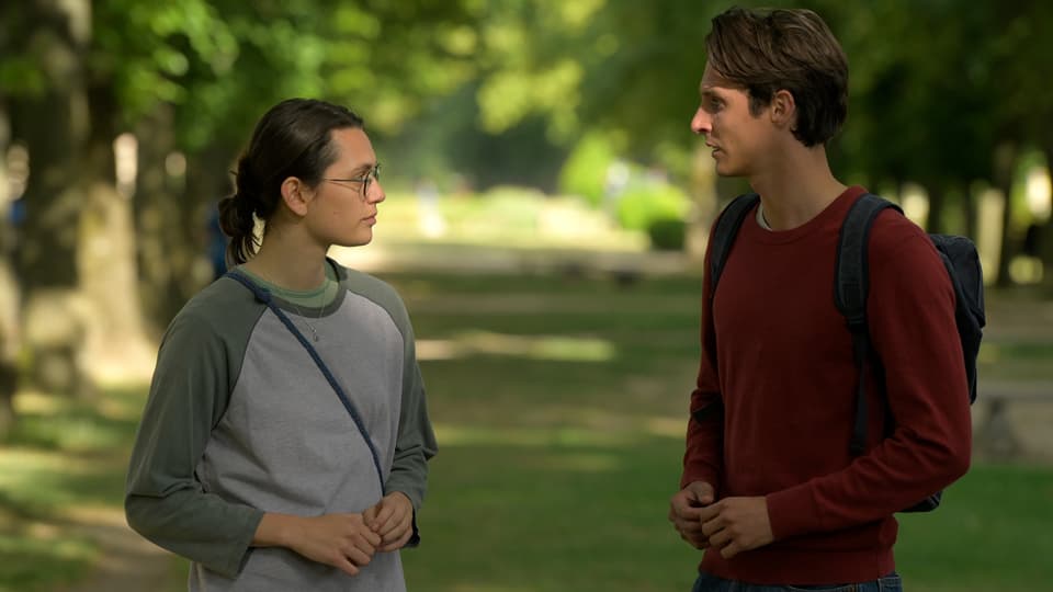 Marguerite (Ella Rumpf) spricht im Park mit ihrem Studienkollegen Lucas, in den sie sich später verlieben wird.