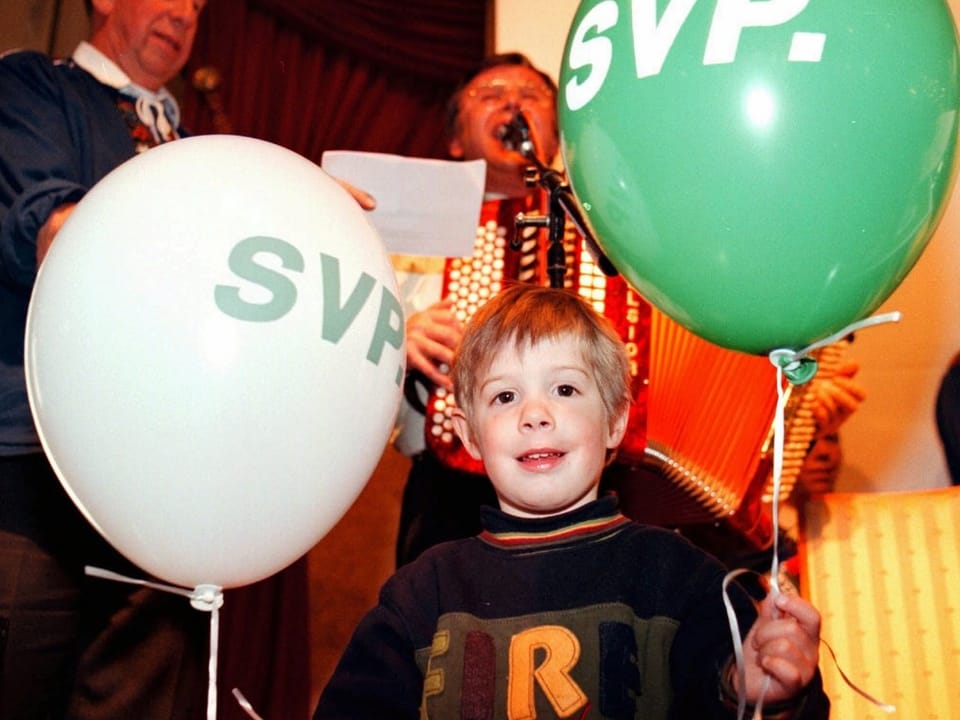 Kind mit Ballonen mit der Aufschrift SVP
