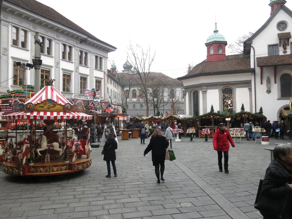 Leute laufen über einen Weihnachtsmarkt in Luzern.