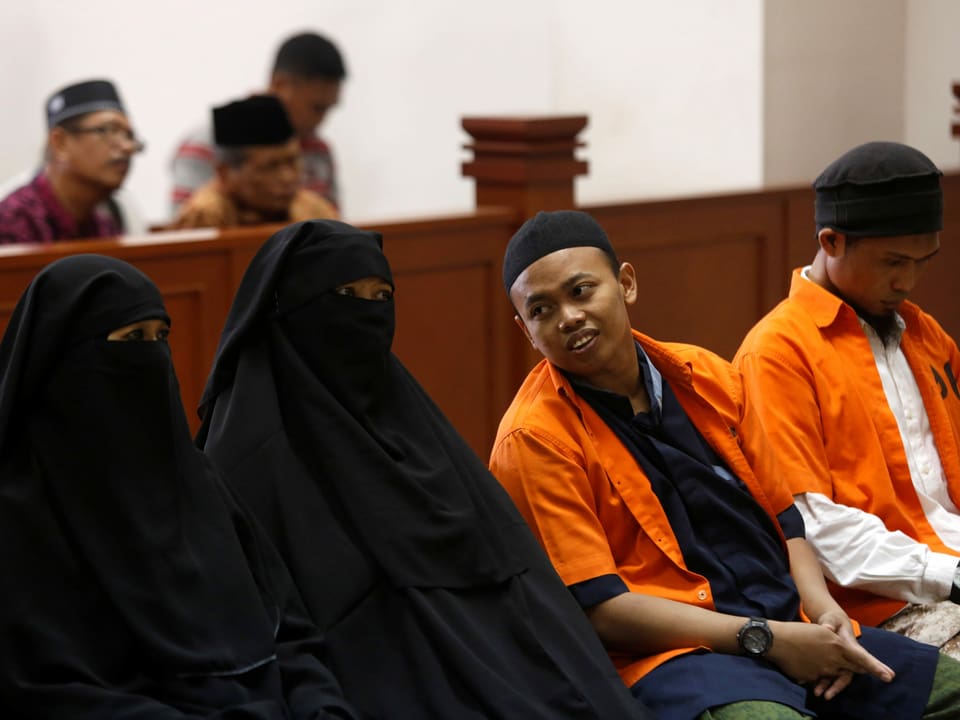 zwei Frauen in Hidschab und zwei Männer vor Gericht
