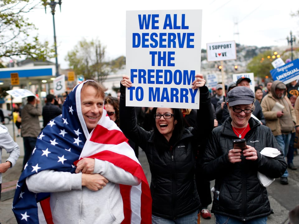 Eine Demonstrantin hält ein Plakat in die Höhe, auf dem «Wir alle verdienen die Freiheit zu heiraten» steht.
