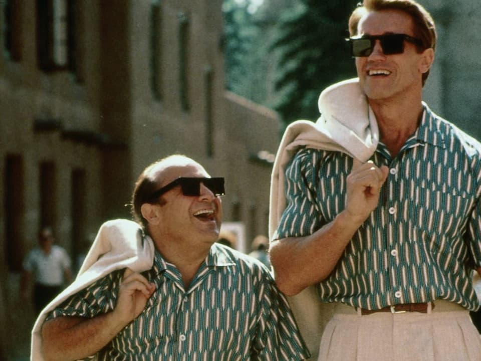Ein Foto von DeVito und Schwarzenegger in den gleichen Hemden und Posen.