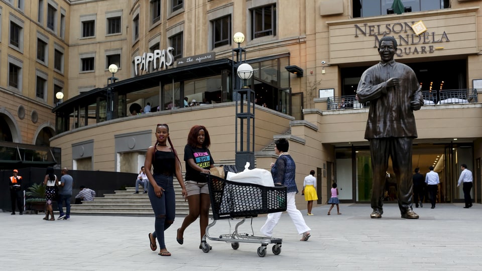 Frauen mit Einkaufswagen vor einem Shopping Center