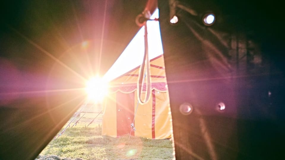 Blick aus einem Zirkuszelt auf ein anderes Zelt. 