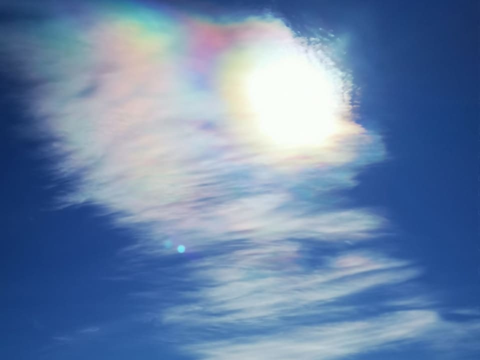 Eiskristalle der dünnen Wolken streuen das Sonnenlicht zu Regenbogenfarben.