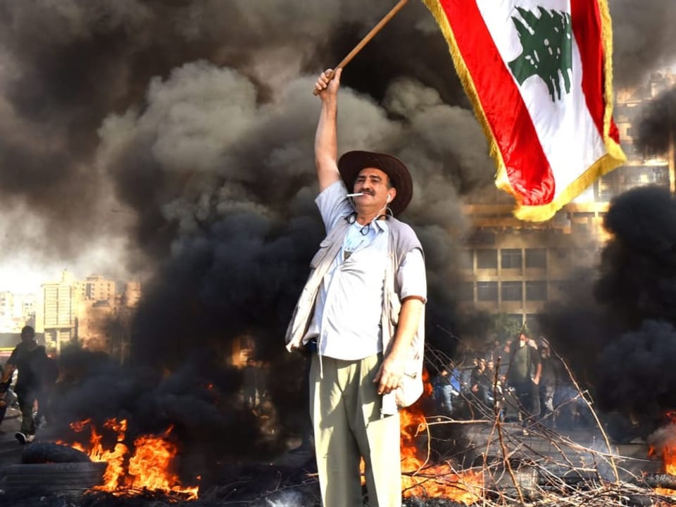 Mann schwenkt libanesische Flagge