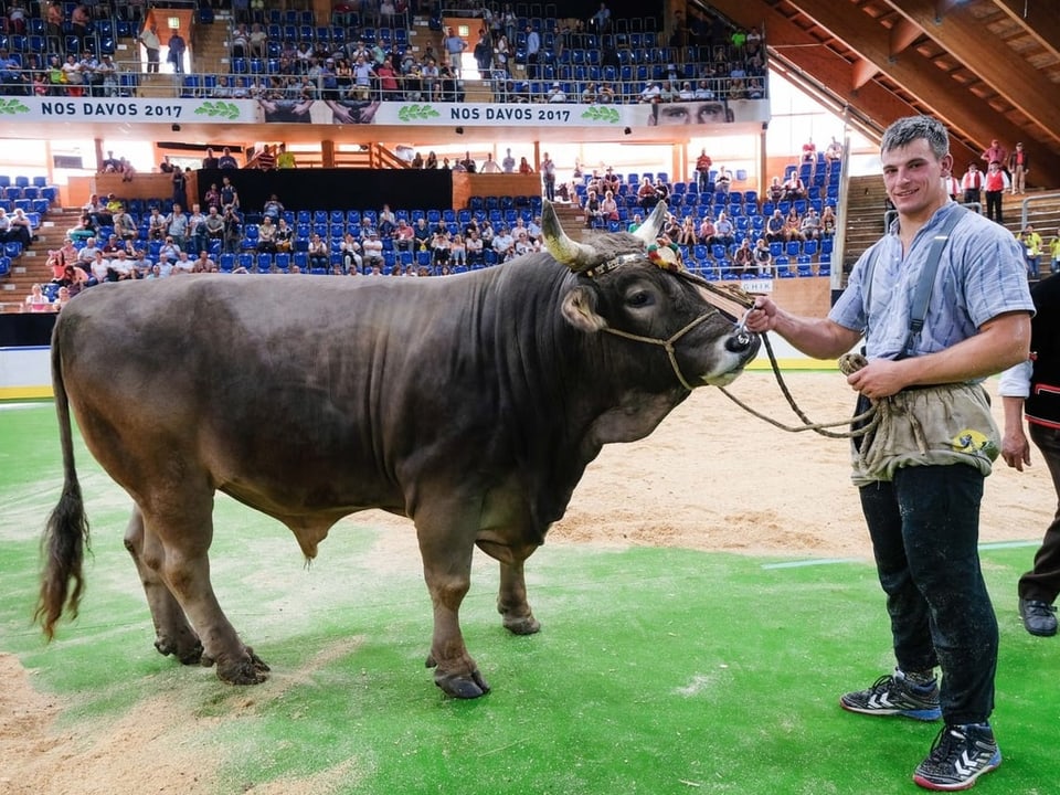 Schwinger Samuel Giger posiert mit Stier Leo.