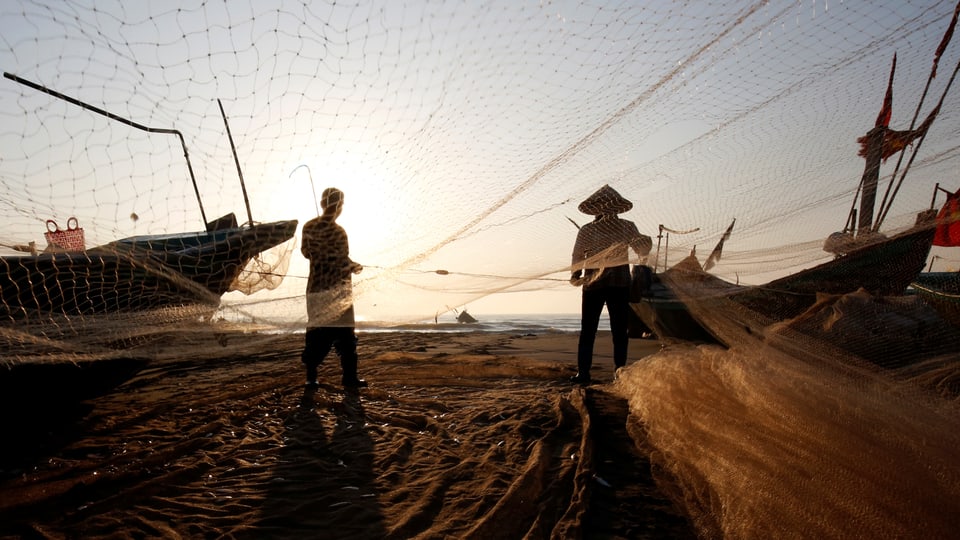 Fischer spannen ihre Netze am Strand auf