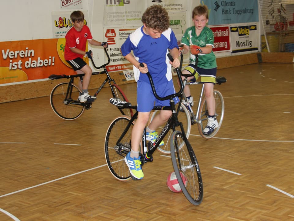 Drei junge Radballer beim Training in der Halle.