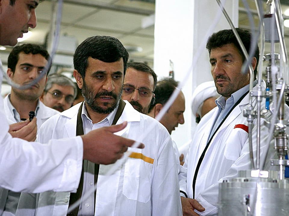 Präsident Mahmud Ahmedinedschad (Bildmitte) schaut eine Maschine an.