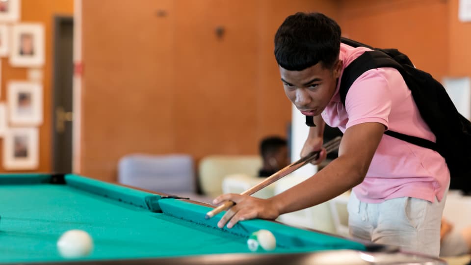 Ein junger Mann an einem Billiard.