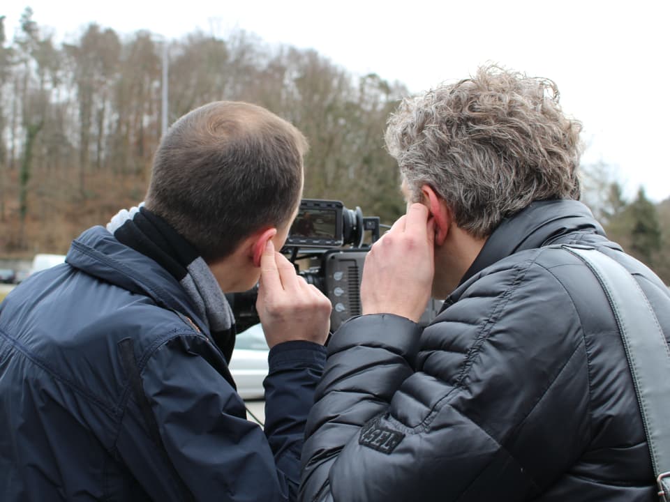 Michael Weinmann und Basil Honegger sehen sich die ersten Aufnahmen des Drehs an.
