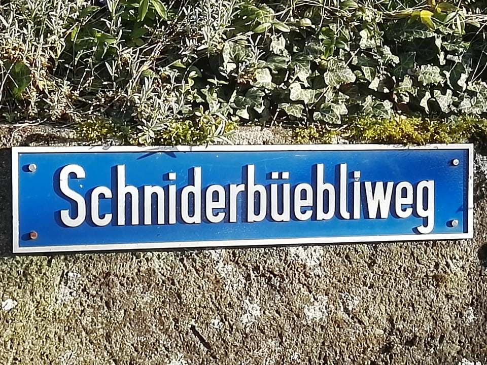 Auf einem Strassenschild steht «Schniderbüebliweg».