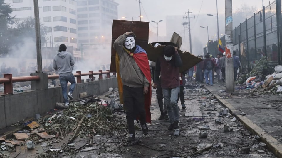 Maskierte Protestierende in den Strassen von Quito.