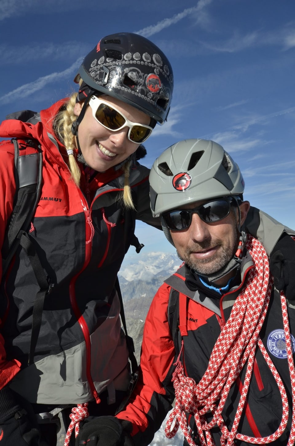 Linda Fäh und ein Bergführer posieren gemeinsam für ein Gipfelfoto auf dem Matterhorn.