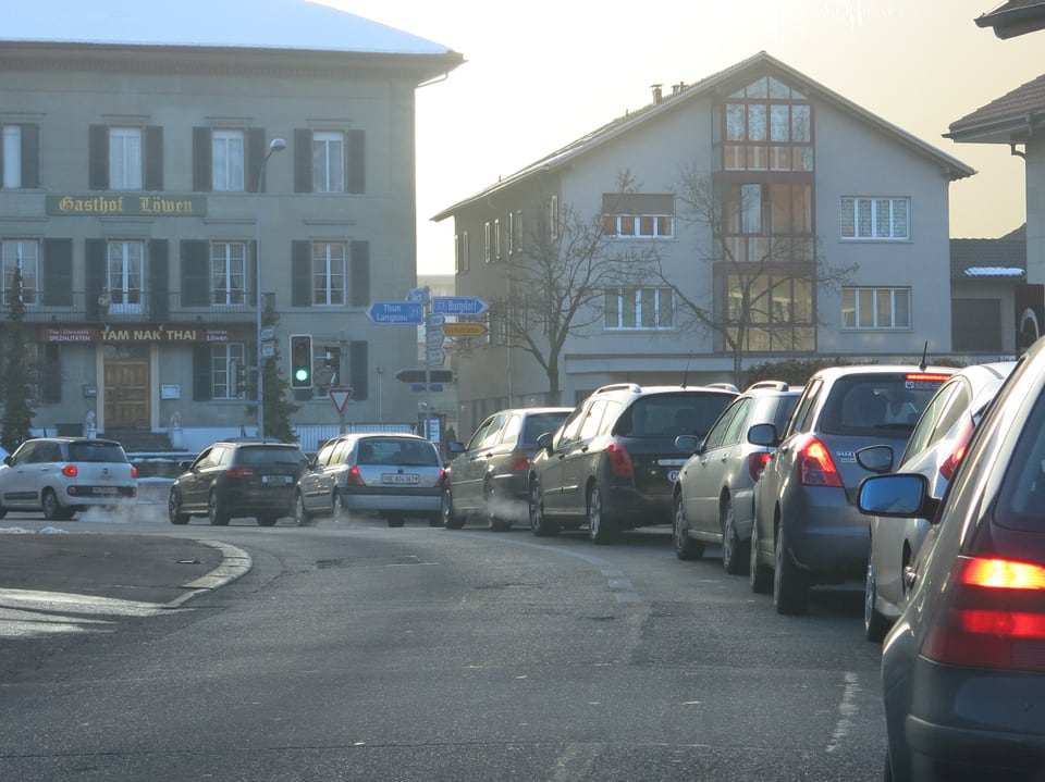 Autos stehen zwischen den Häuserzeilen im Stau.