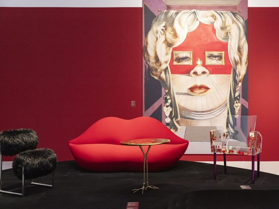 Rote Wand, darauf Bild von Mae Wests Gesicht (v. Salvador Dalí). Davor: Rotes Sofa in Form von Lippen.