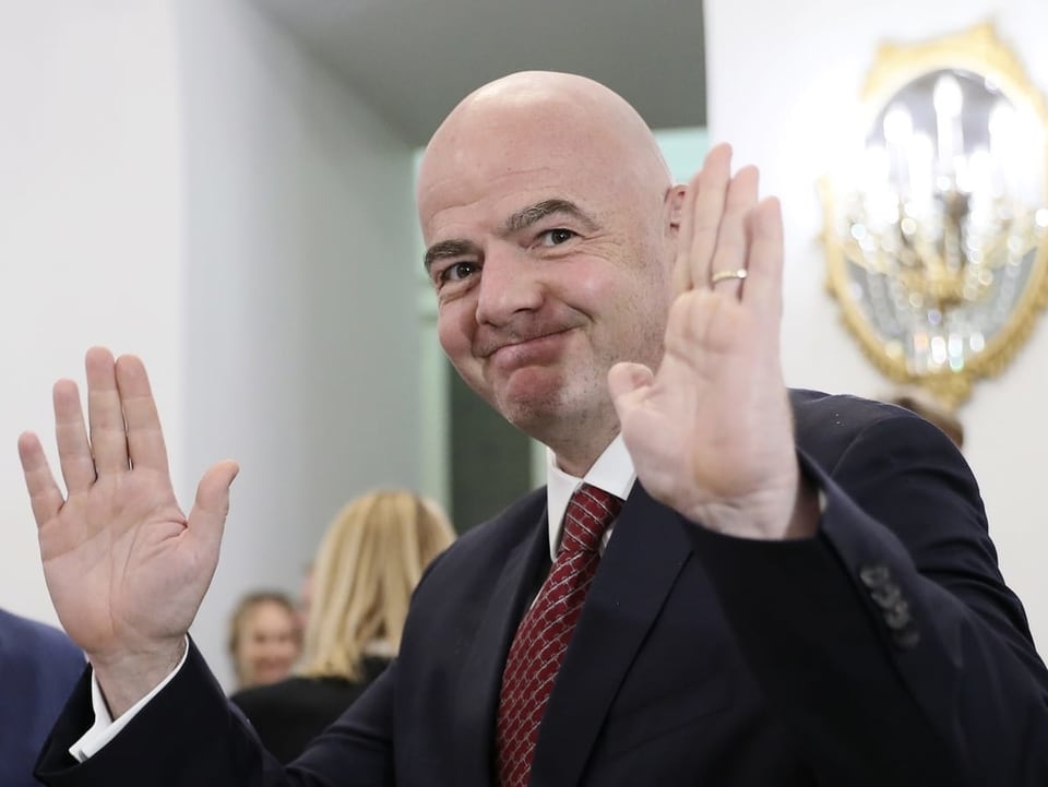 Gianni Infantino grüsst mit beiden Händen in die Kamera.