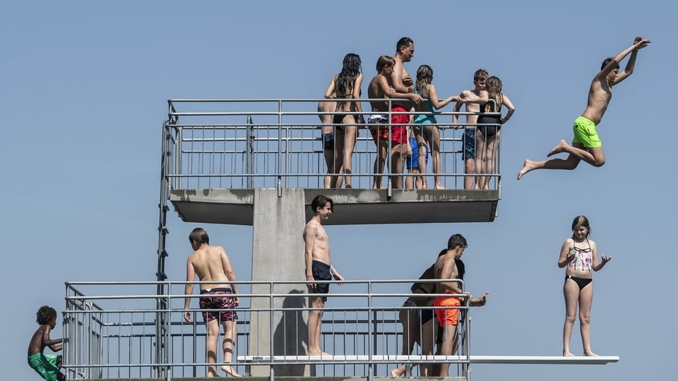 Menschen auf dem Springturm im See