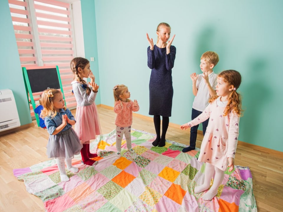 Kinder, die mit einer Lehrerin singen
