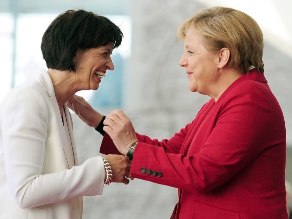 Leuthard und Merkel umarmen sich und lachen.