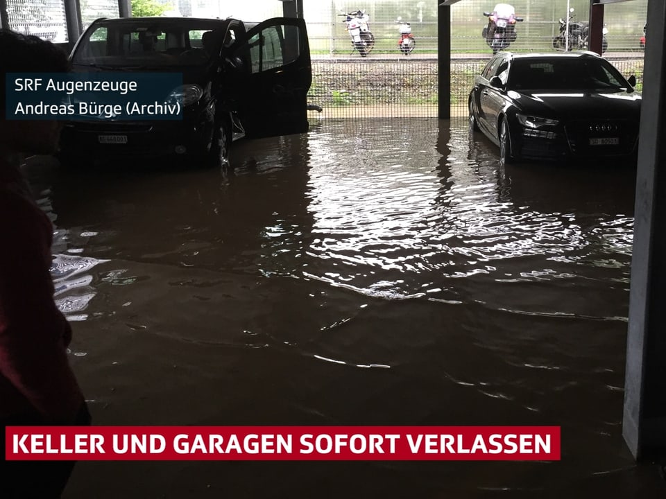 Garage mit Wasser auf dem Boden. Die Autos stehen im dreckigen Wasser. 