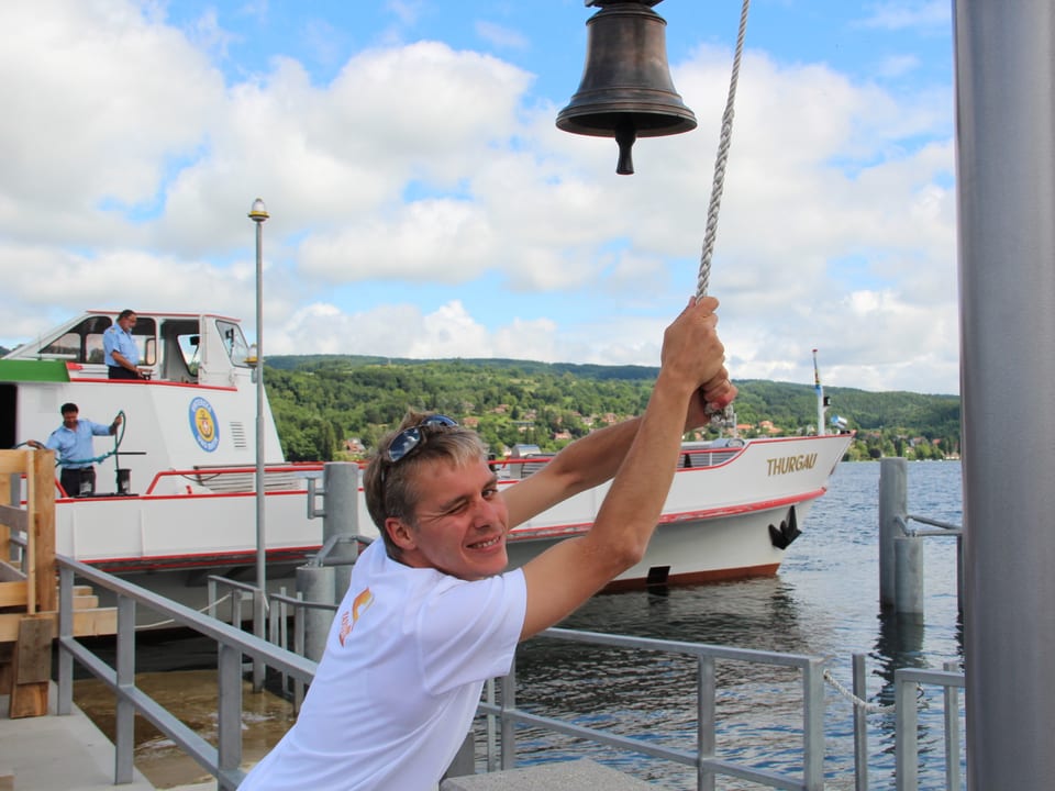 Reto Scherrer zieht auf einem Steg an der Leine einer Schiffsglocke.
