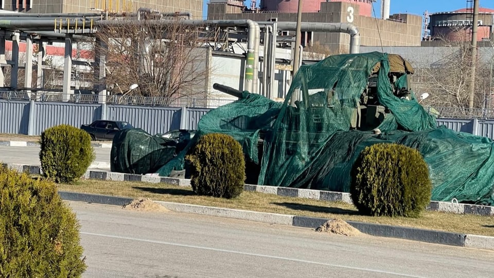 Ein verhüllter Panzer steht vor dem AKW Saporischja