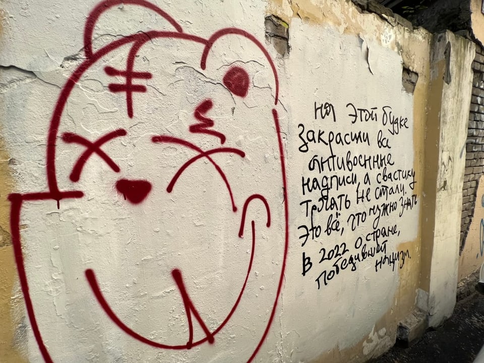 Graffitis auf einer heruntergekommenen Mauer.