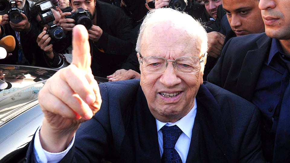 Der designierte tunesische Präsident Béji Caïd Essebsi steigt aus einem Auto und hebt den Zeigefinger.