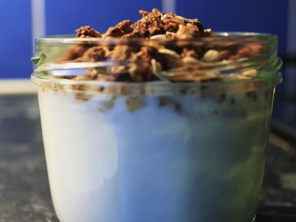 Ein Konfiglas gefüllt mit Joghurt und Crunchy-Müesli