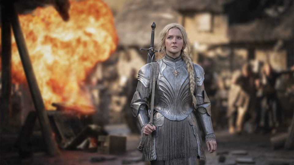 Blonde Frau in Rüstung und mit Schwert vor Explosion