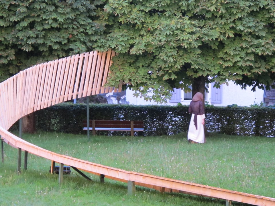 Ausschnitt der Bühne mit einer Schauspielerin, welche mit dem Rücken zum Publikum steht.