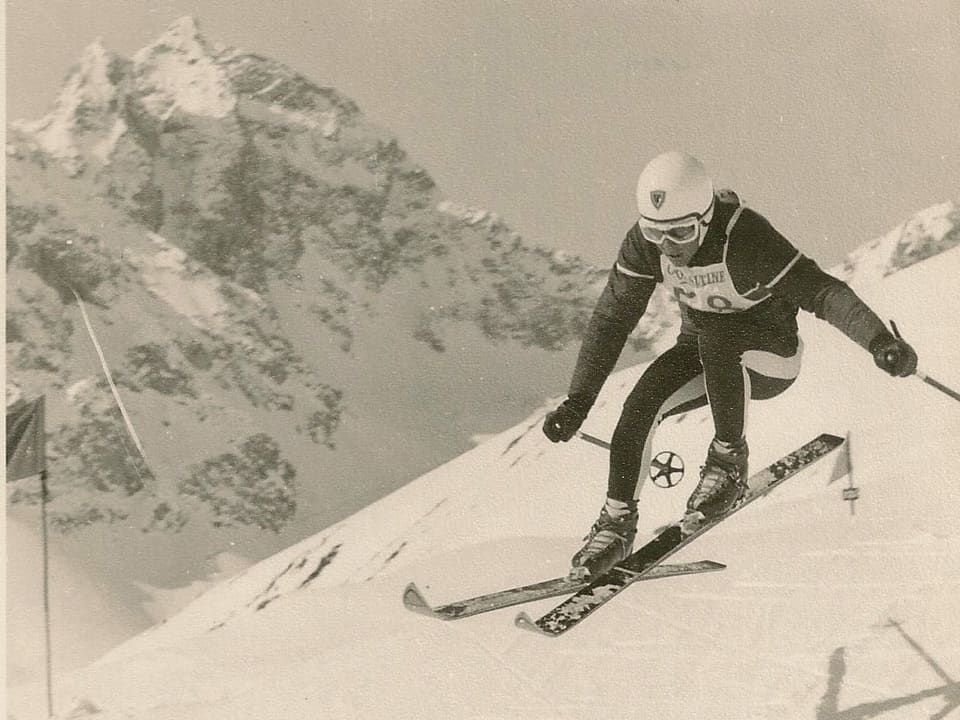 Schwarz-Weiss-Fotografie von einem Skifahrer während eines Rennens.