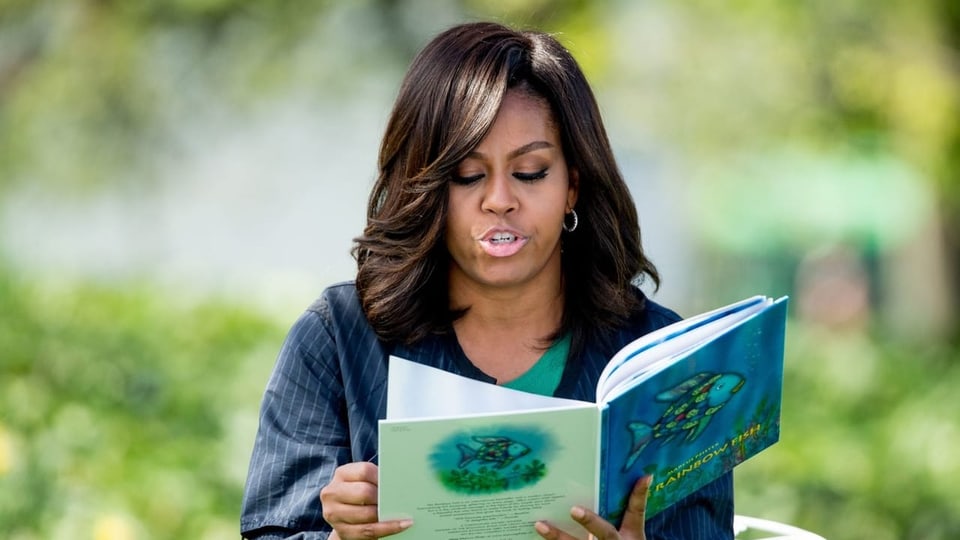 Michelle Obama sitzt und liest aus «Rainbow Fish» vor.