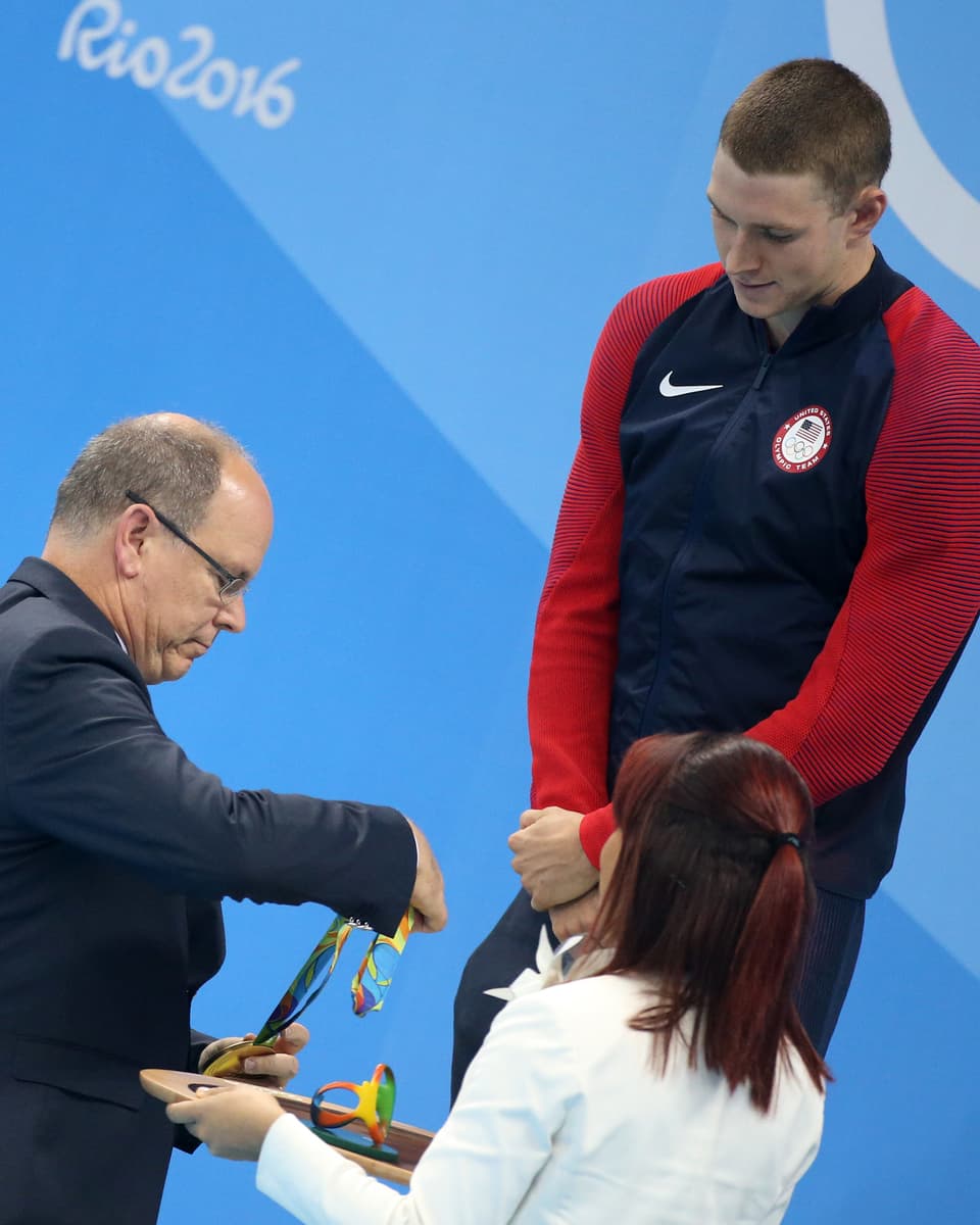Übergabe der Goldmedaille. Der Athlet wartet darauf, dass Prinz Albert ihm die Medaille umhängt.