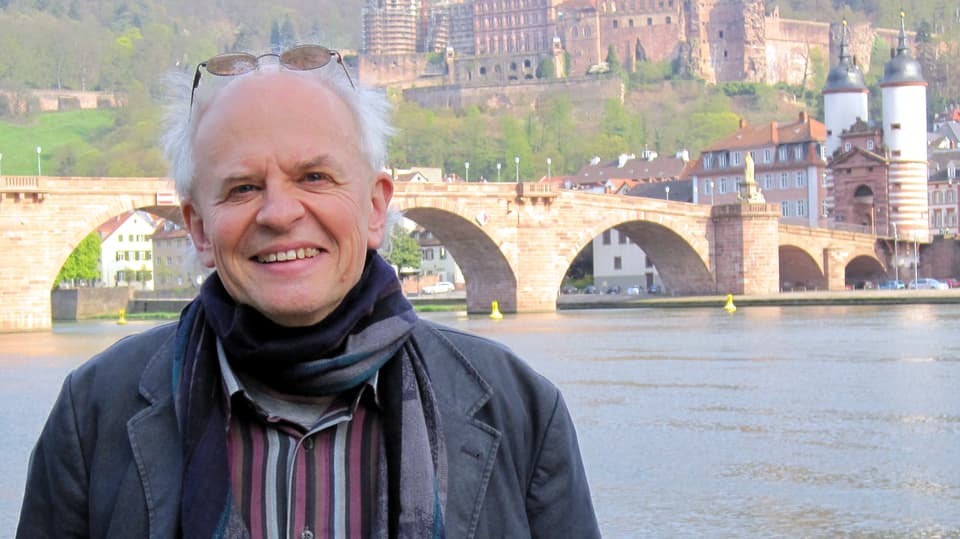 Der Autor Ralph Dutli im Porträt vor einer Brücke.