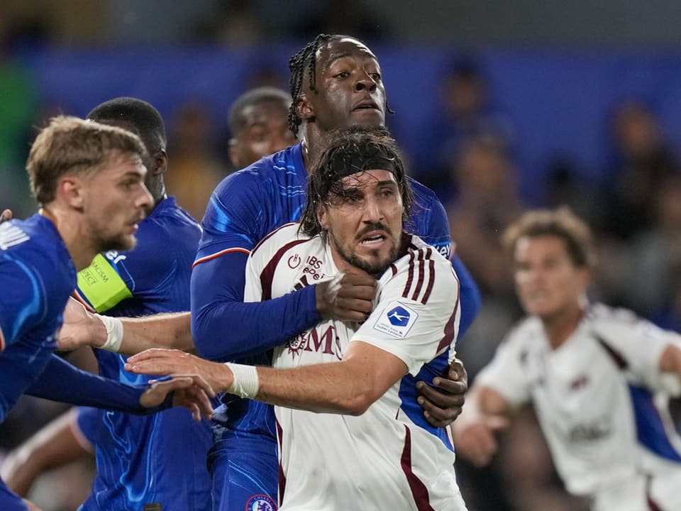 Também não tive sorte no jogo de ida Jogadores de futebol com camisas azuis e brancas lutam pela bola.