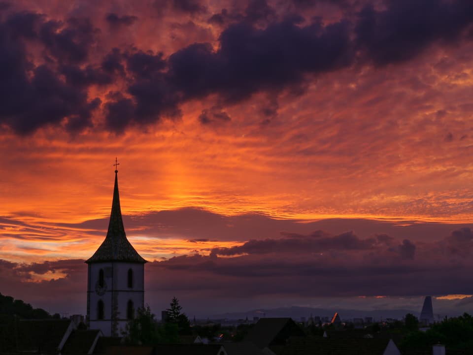 Sonnenuntergang mit Kirchturm.