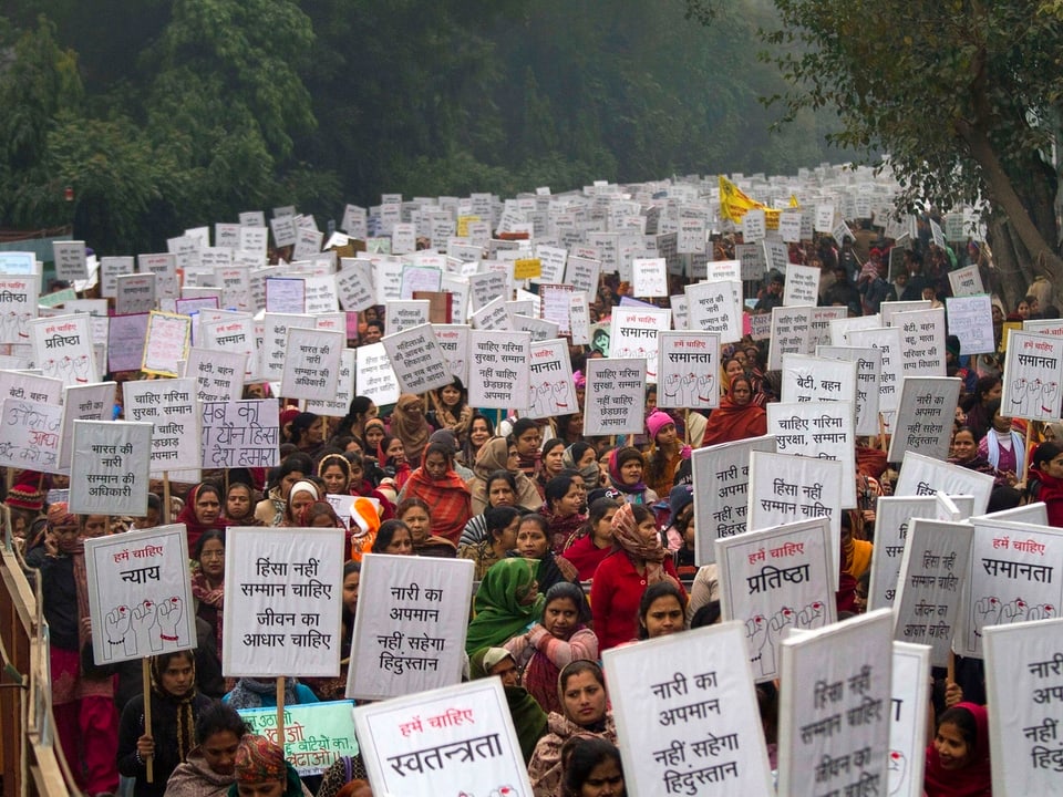 Hunderte Frauen protestieren mit Plakaten gegen die Vergewaltitungen