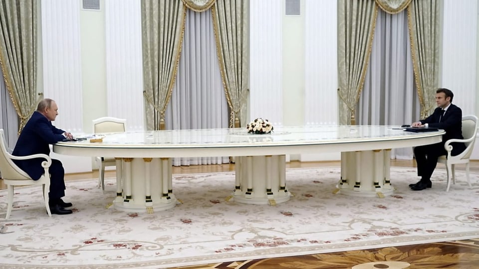 Putin sitzt am linke, Macron am rechten Ende eines meterlangen ovalen weissen Tisches.