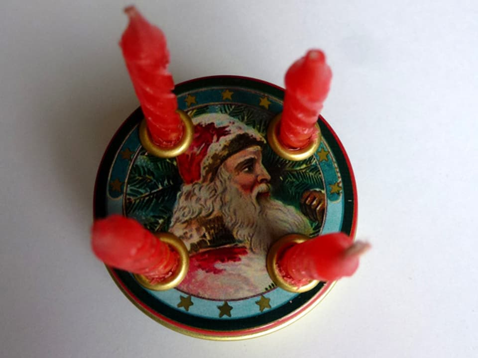 Kleiner Adventskranz mit einem Durchmesser von 45 mm und einer Höhe von 50 mm. Kerzen stehen auf einem runden Teller mit Nikolaus-Sujet.