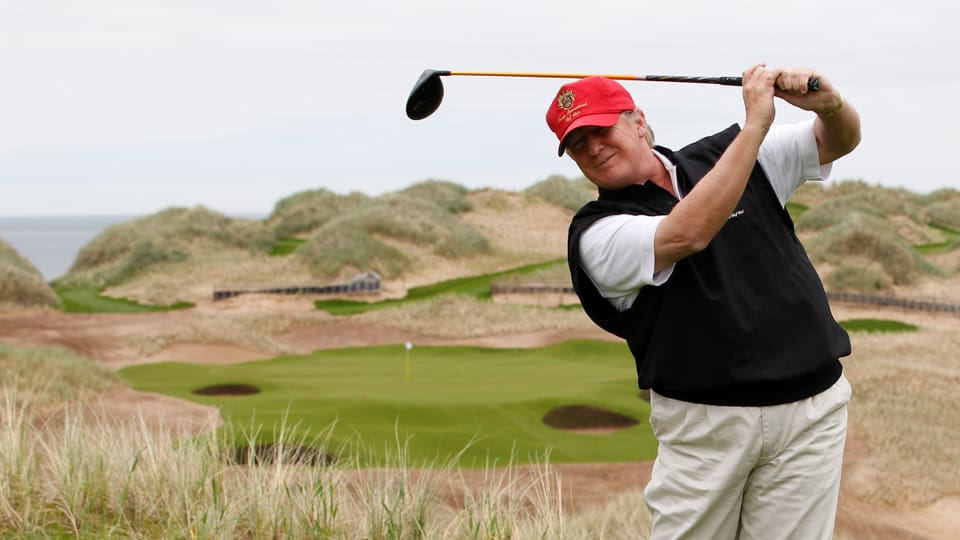 Trump mit Golfschläger auf Golfplatz.