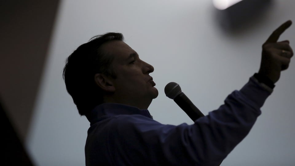 Ted Cruz als Silhouette – mit der rechten Hand und ausgestrecktem Finger zeigt er schräg nach oben.