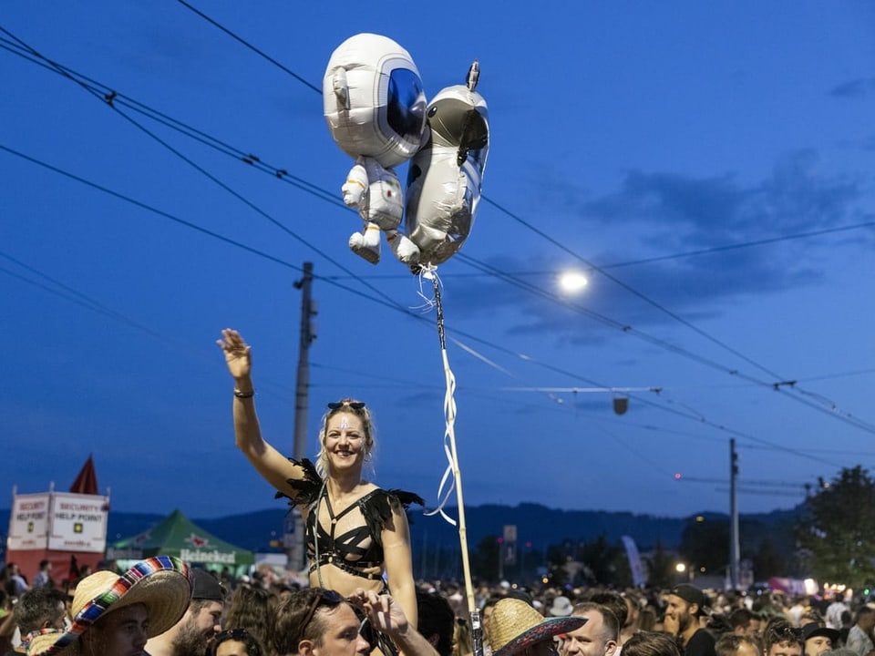 Menschenmenge, eine Frau und Ballons