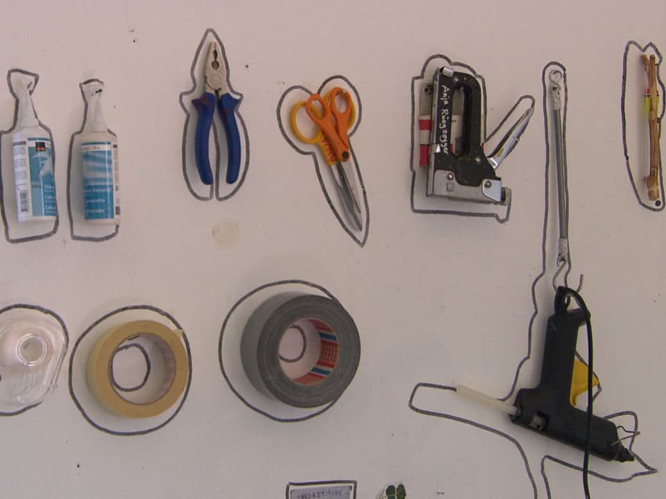 An die Wand gehängtes und mit Filzstift umrandetes Werkzeug im Atelier von Anja Rüegsegger.