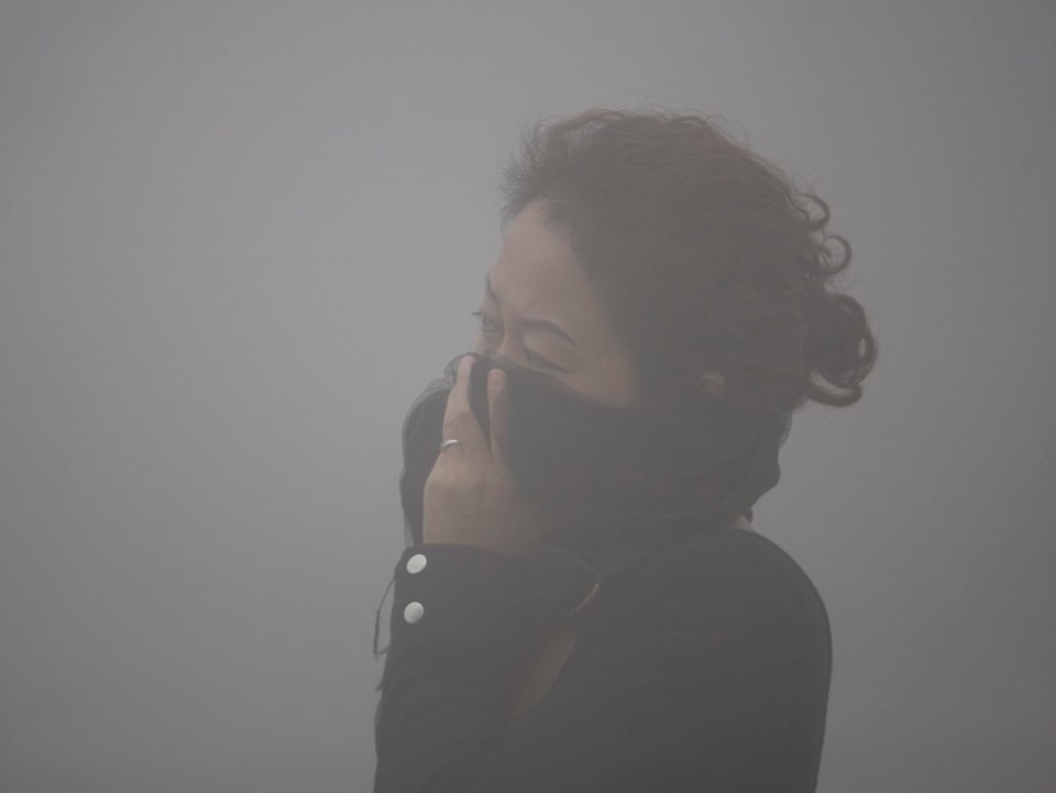Frau im Smog schützt sich mit ihrer Kleidung