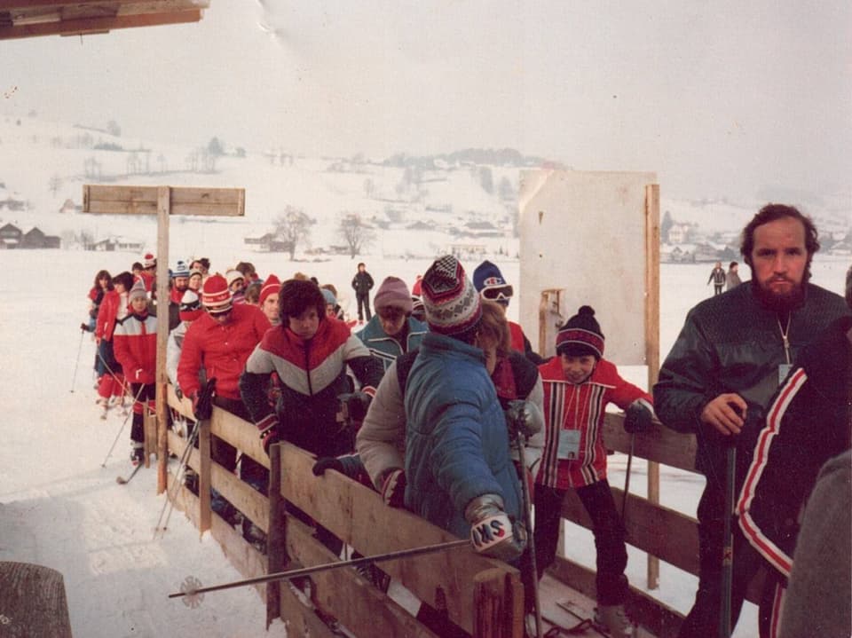 Zahlreiche Skifahrer am Anstehen am Lift. 