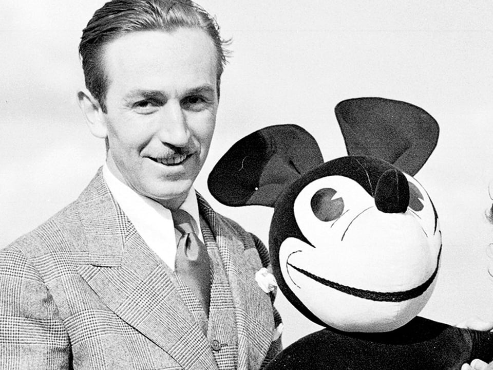 Walt Disney mit einer Micky-Maus-Puppe.