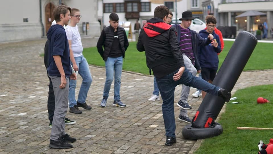 Eine Gruppe Jugendliche steht um einen Boxsack